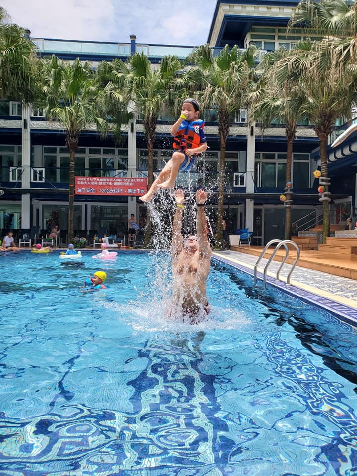 throwing child in the air in swimming pool